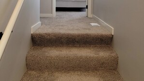 A carpeted staircase leading to a bedroom with a bed and a window. - Stylish Family Townhome with Relaxing Deck Views (Omaha)