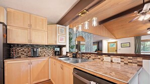 Una cocina moderna con armarios de madera, encimera de mármol y lavavajillas.
