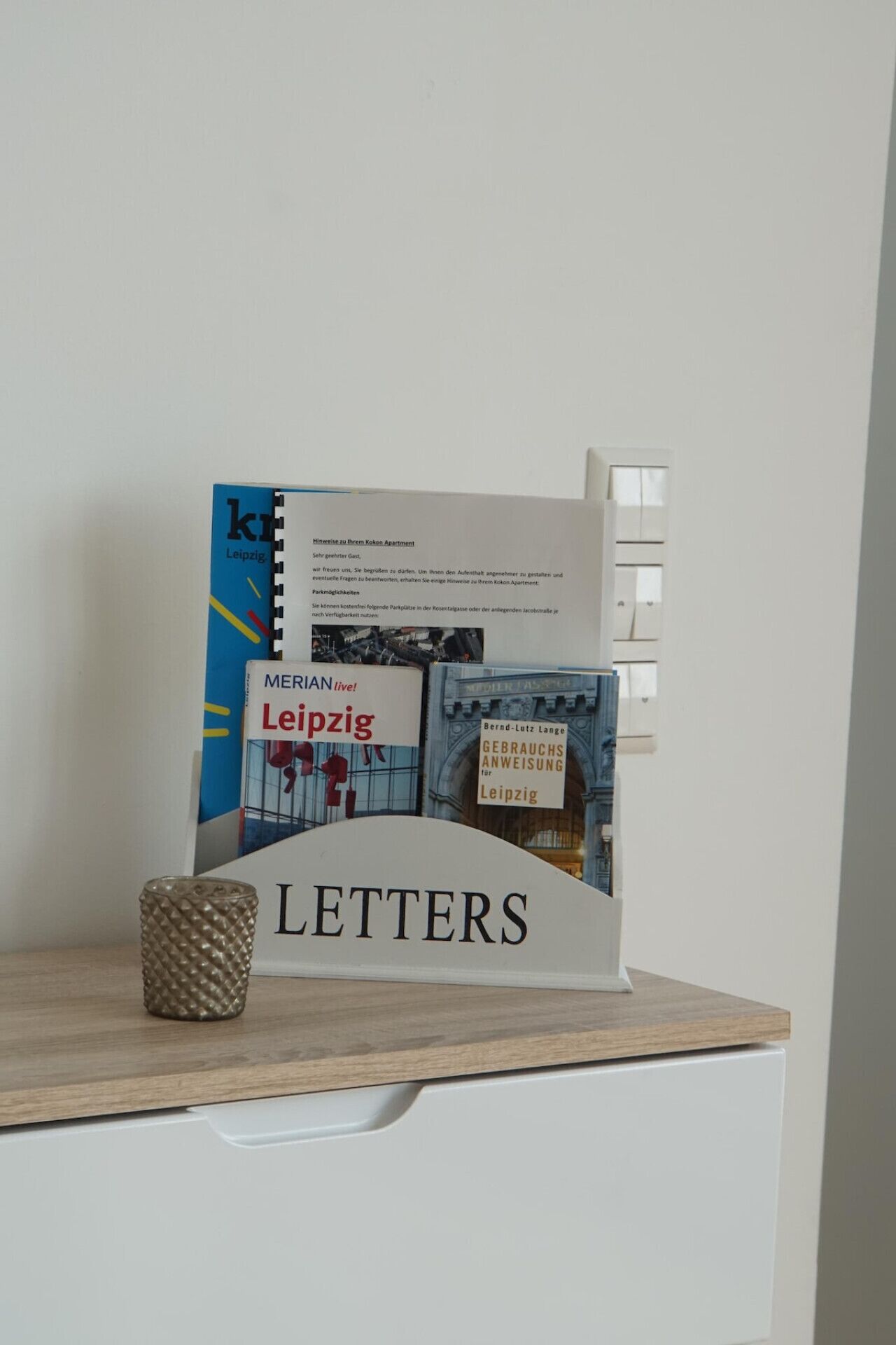 Un escritorio con un libro titulado 'Leipzig' y un cartel que dice 'LETTERS'.