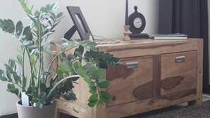 Ein Holzkabinent mit zwei Schubladen und einer kleinen Uhr darauf.