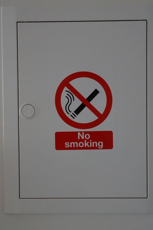 A door with a no smoking sign and a red "No smoking" label.