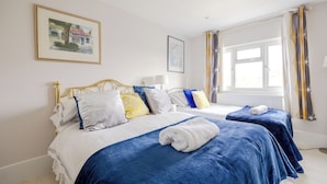 A hotel room with two beds, a large window with curtains, and artwork on the walls. - Wavertree Hotel (London)