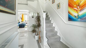 A staircase with a grey carpet, white walls, and a large abstract painting on the right. - Wavertree Hotel (London)