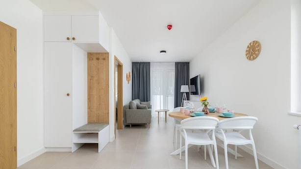 Habitació moderna i ben il·luminada amb zona de menjador, sofà i televisió.