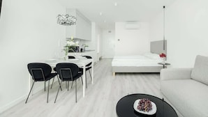 A modern, minimalist living space with a dining area, a sofa, and a coffee table. - Modern Studio | Close to Beach and Lake, Parking. (Mielno)