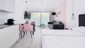 Ein modernes Hotelzimmer mit Küchenzeile, Essbereich, Sofa und Bett.