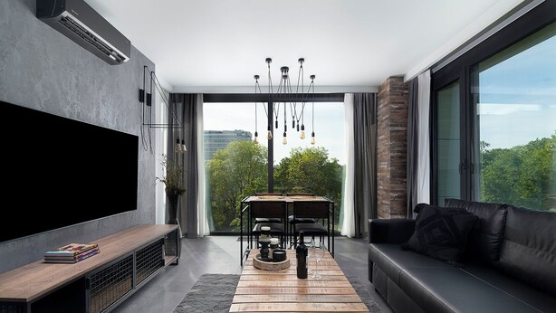 Un salon moderne doté d’un téléviseur à écran plat, d’une table basse en bois, d’un canapé en cuir noir et d’un coin repas avec une table et des chaises.