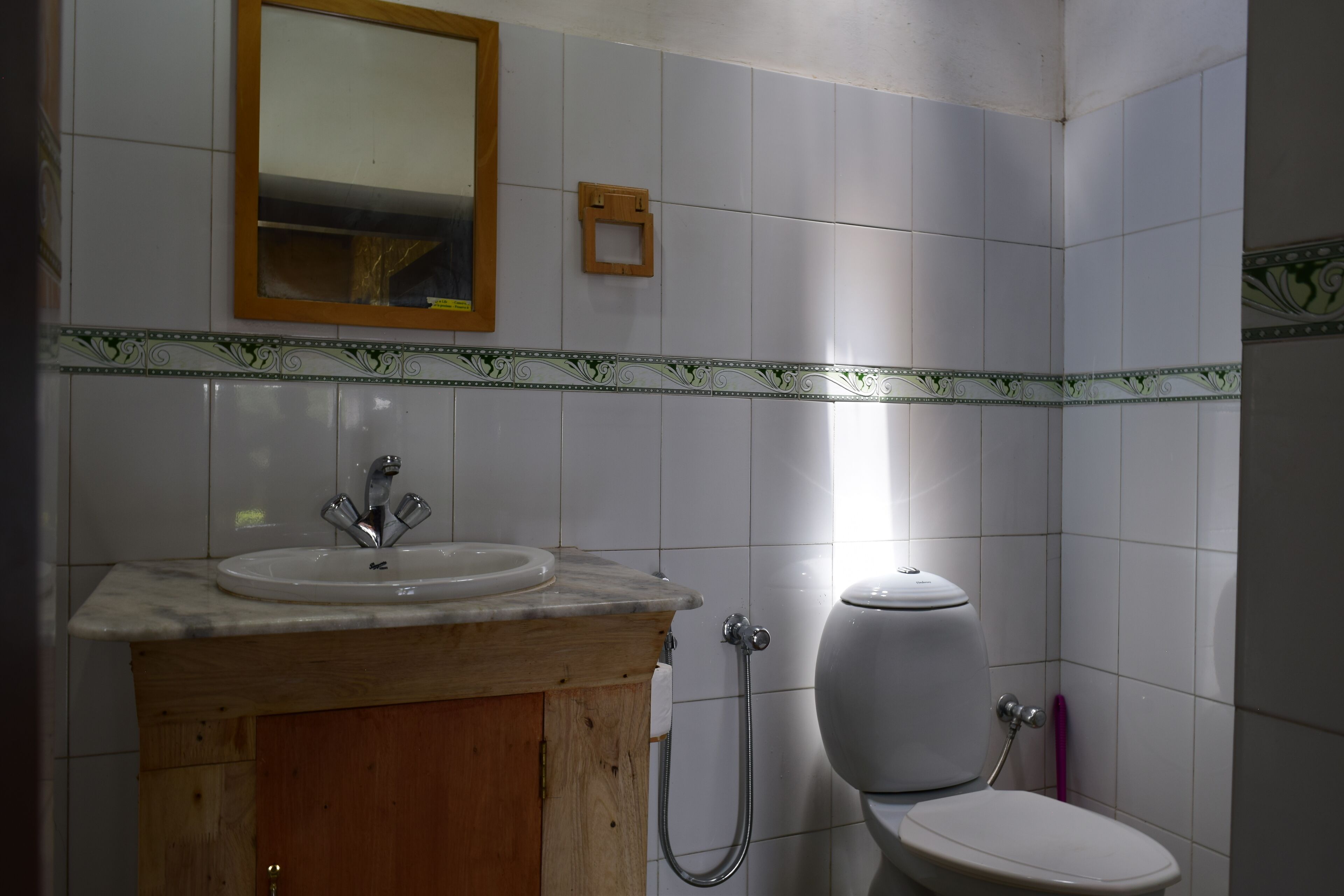 Een badkamer met een wastafel, spiegel, toilet en douche.