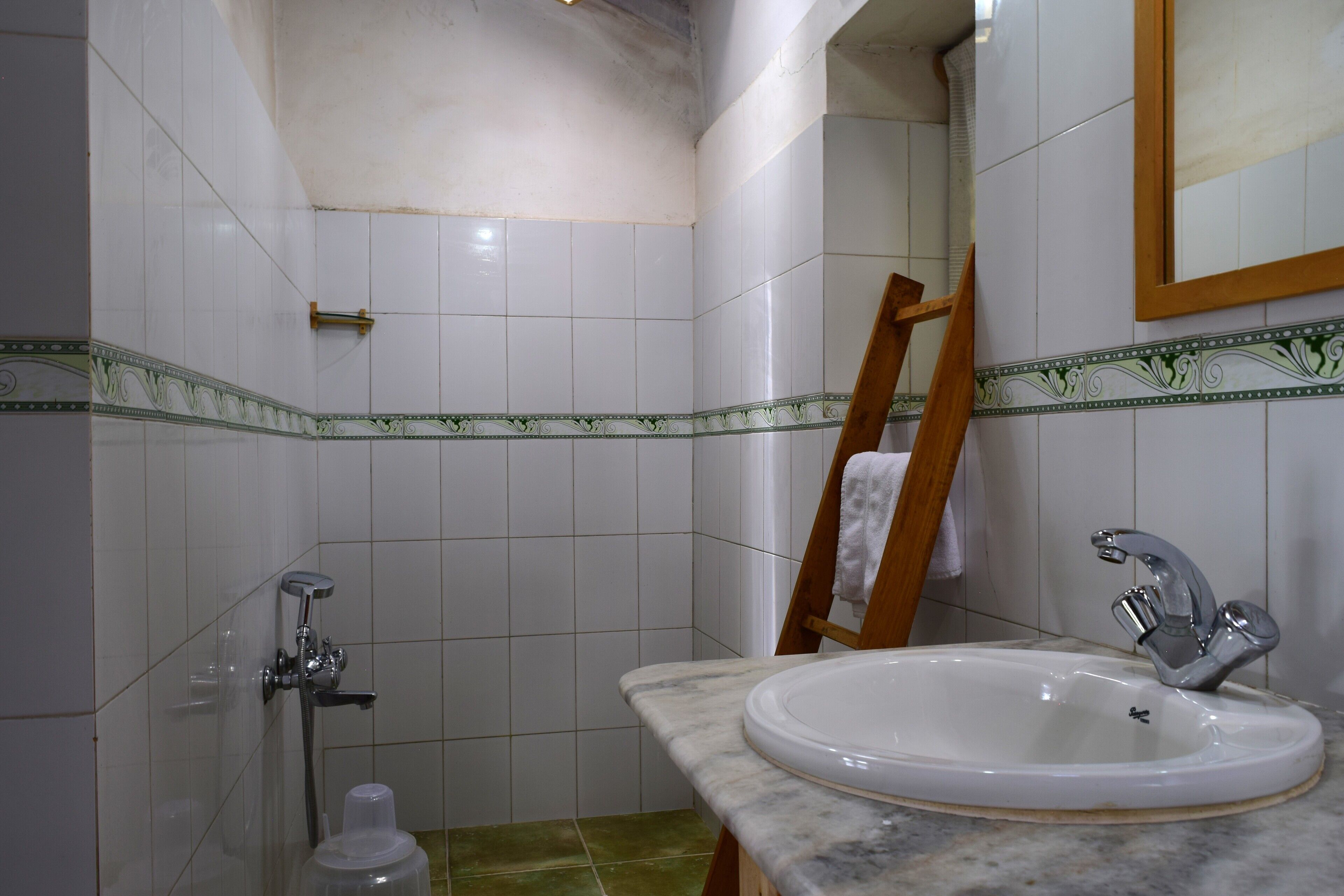 Un baño con lavamanos, espejo y ducha.