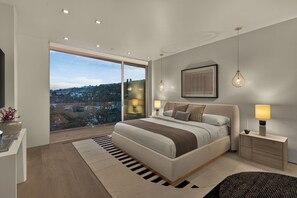 Una camera da letto moderna con un letto grande, abat-jour, vista panoramica attraverso una porta vetrata e un quadro appeso al muro.