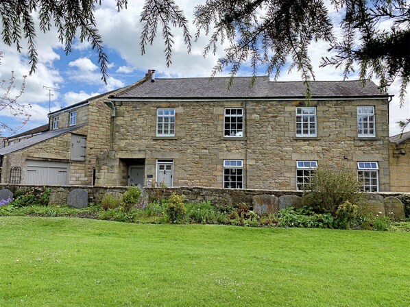A stone building with multiple windows and a grassy lawn in front. - St Lawrence Rest - Cosy Retreat in Warkworth (Morpeth)