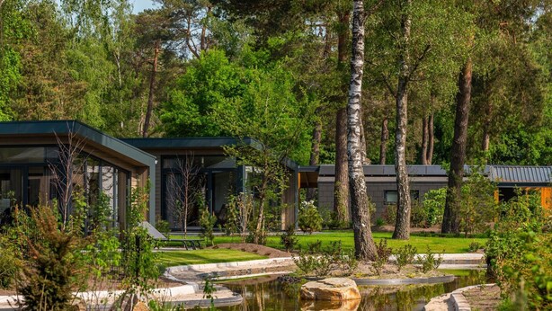 A modern building with large windows and a pond in the foreground. - Modern Home Near Hoge Veluwe (Arnhem)