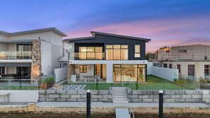 A modern two-story house with a balcony, a small patio, and a swimming pool. - Ultimate luxury on the canal (Geographe)