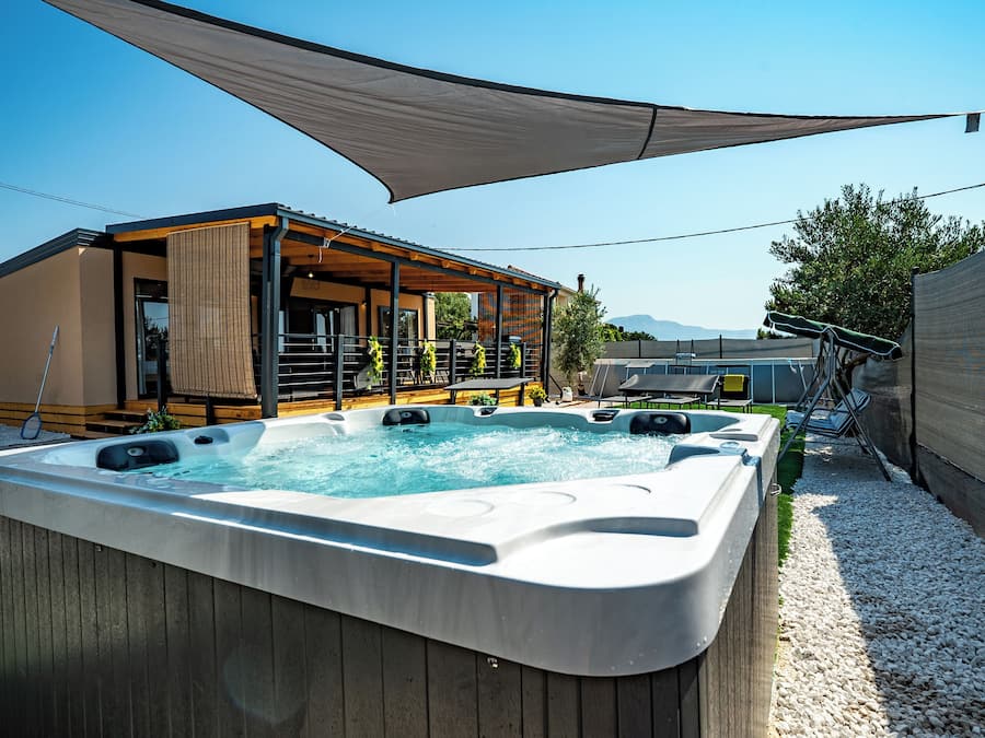 Un jacuzzi con una terraza de madera y una zona de estar cubierta.
