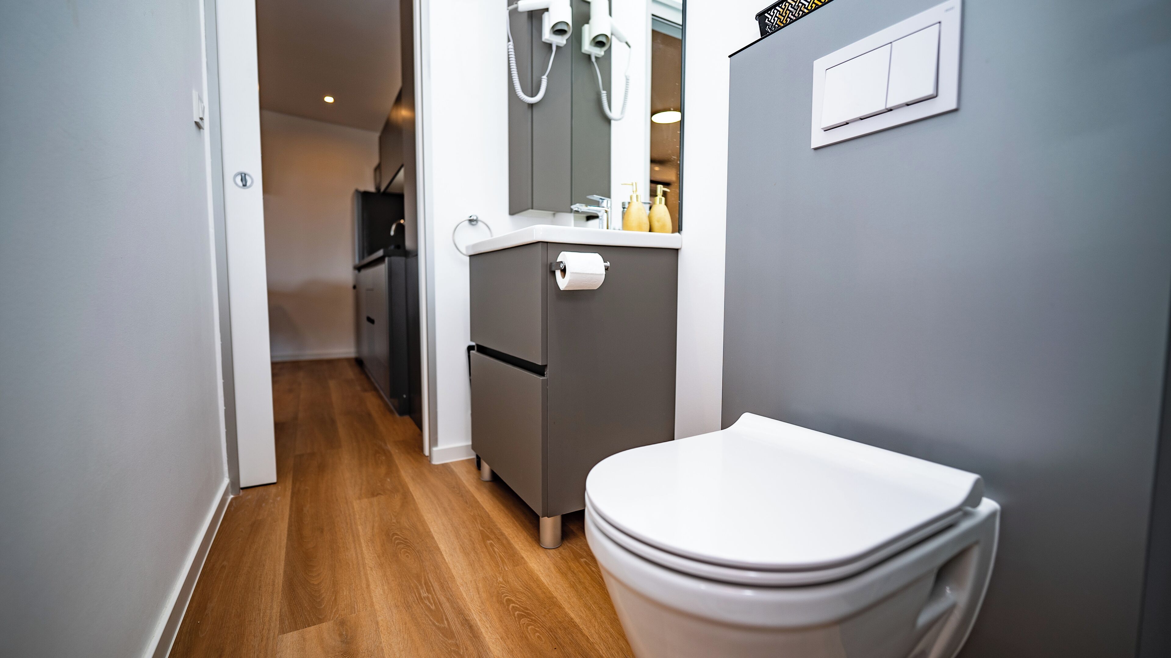 Ein kleines Badezimmer mit Toilette, Waschbecken und Spiegel.