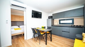A compact, modern apartment with a kitchenette, a dining area, and a bed. - Red Eirth Kastel Stafilic (Kastela)