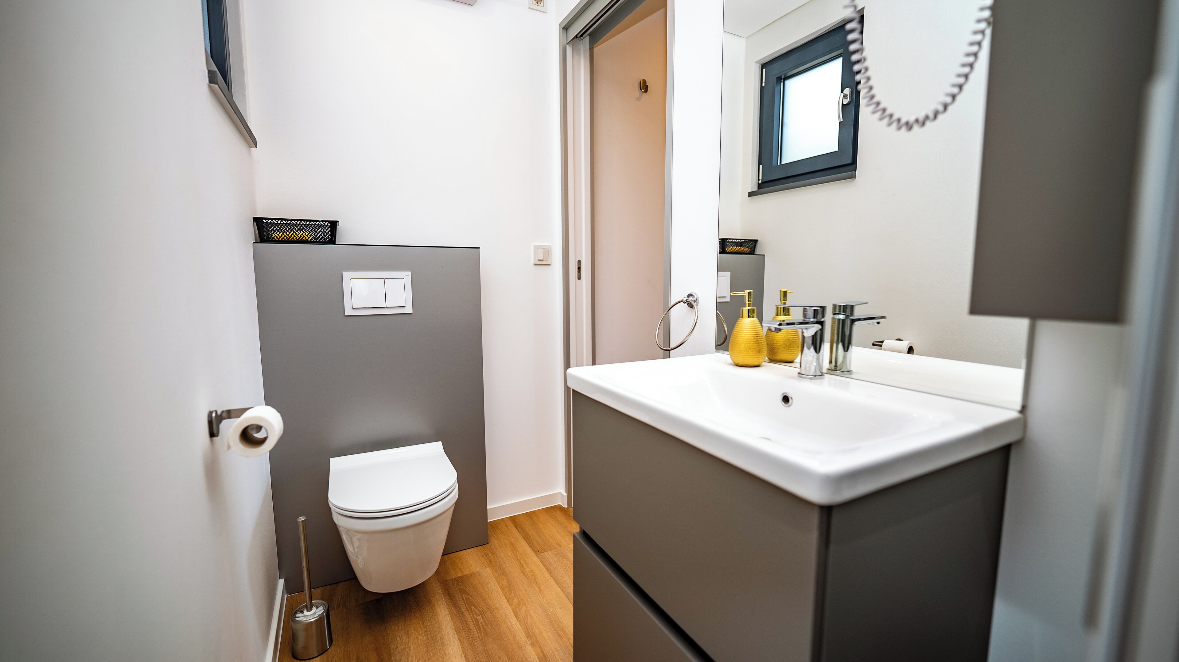 Ein kleines Badezimmer mit Toilette, Waschbecken und Spiegel.