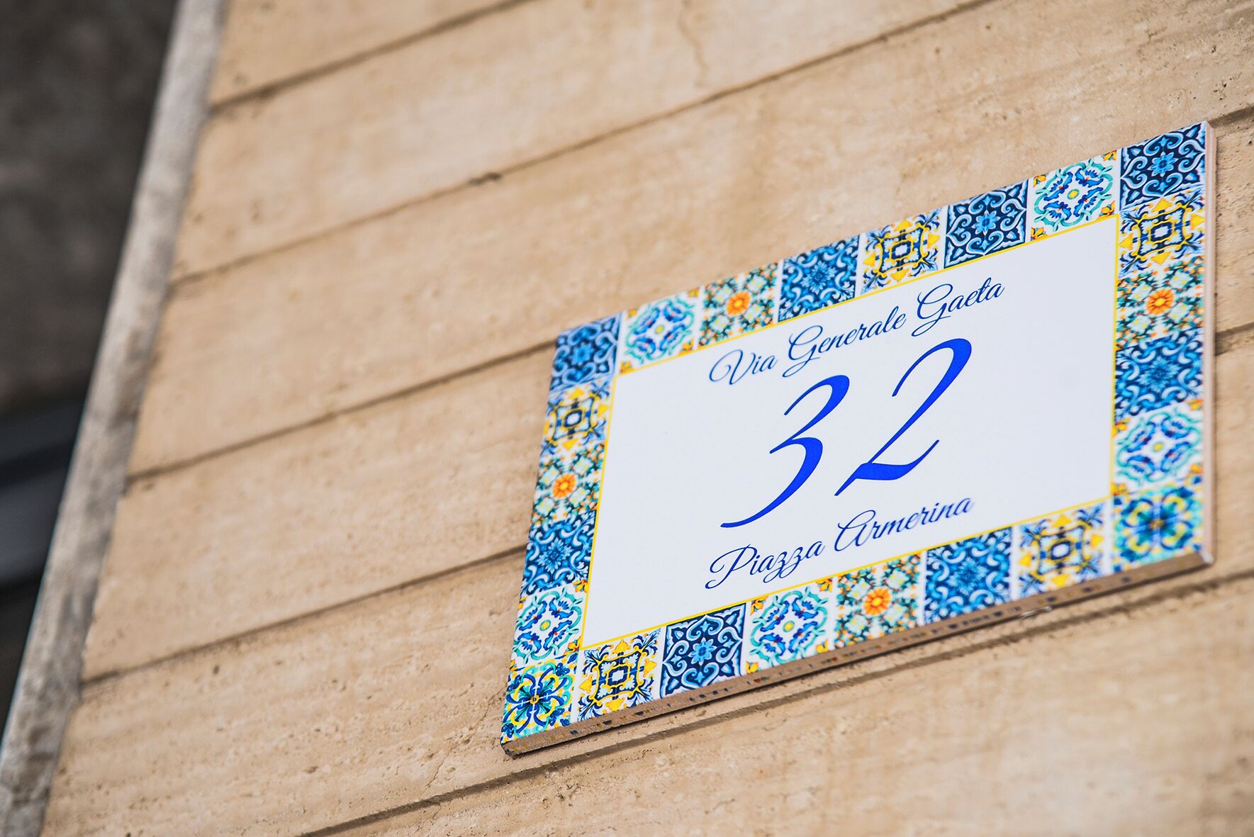 A sign with the number 32 and the text "Via Generale Gaeta Piazza Armirina" on a building facade.