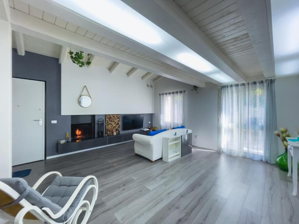 Un salon moderne avec une cheminée, un canapé blanc et un coin repas.