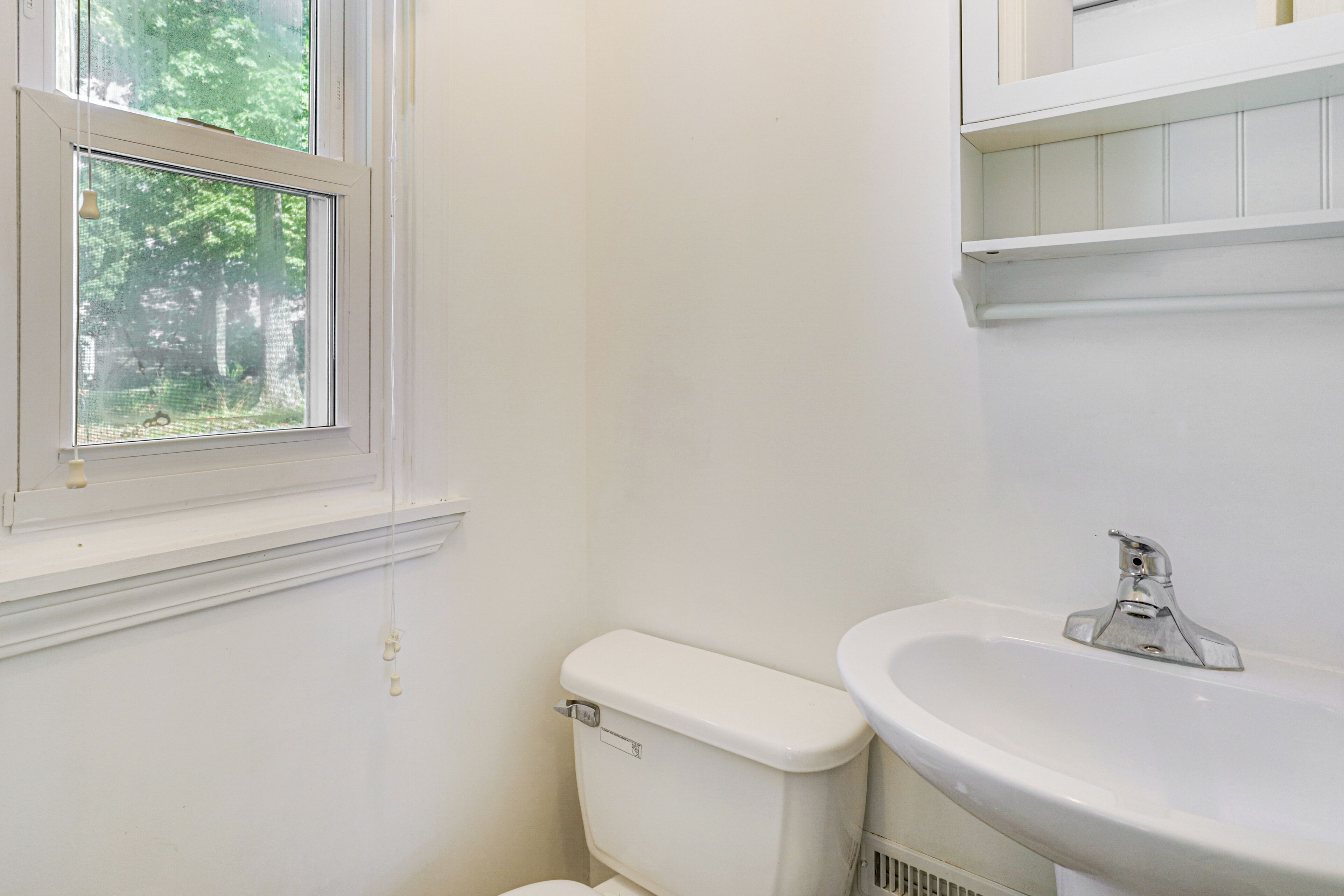 Ein Badezimmer mit Toilette, Waschbecken und Fenster.