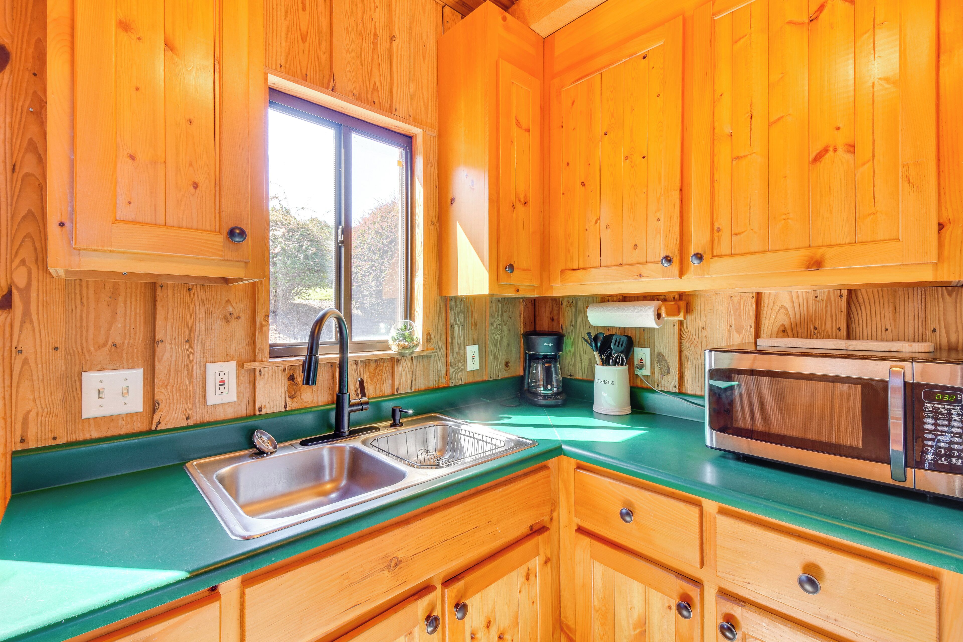 Cucina di una baita in legno con lavello, macchina per il caffè e forno a microonde.