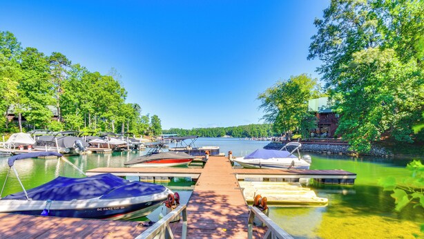 A dock leading to a marina with boats and a building in the background. - Lake Keowee Retreat: Idyllic Six Mile Cabin! (Six Mile)