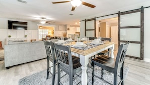 A dining area with a wooden table set for four, surrounded by dark chairs. - Spacious Tavares Home w/ Private Outdoor Oasis! (Tavares)