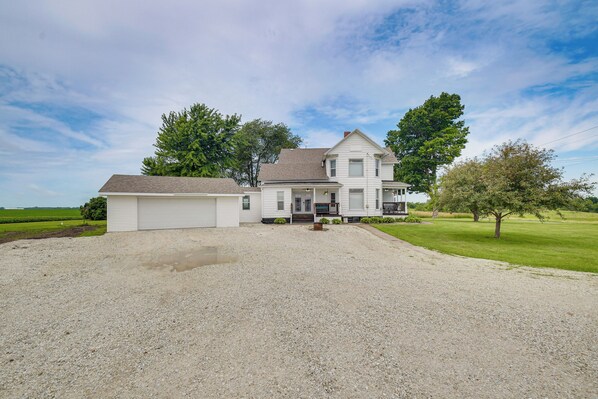 A two-story house with a front porch, a garage, and a well-maintained lawn.