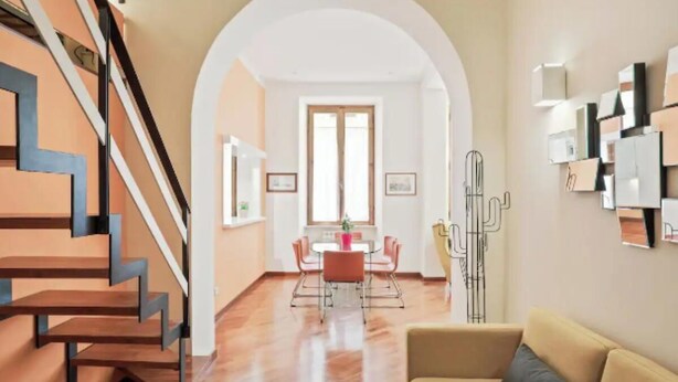 Un intérieur moderne comprenant un escalier, un coin repas et un espace de vie.