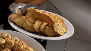 A plate of sliced sponge cake and a plate of round pastries.
