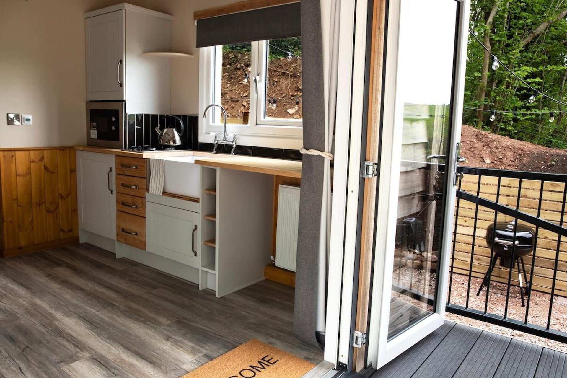 Een moderne keuken met witte kasten, een zwart aanrecht en een inbouwoven.