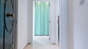 A hallway with a door on the left, a patterned curtain at the end, and a thermostat on the wall. - La Foresteria Termoli 4, your home away from home by the sea and central (Termoli)