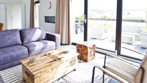 Una sala de estar moderna con un sofá, una mesa de centro de madera y una silla.