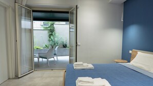 A hotel room with a bed, a chair, and a small table. - CATANIA E DINTORNI LIVING ROOMS (Catania)