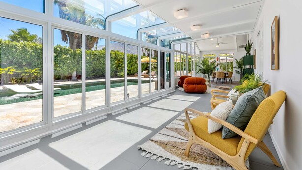 Un espace intérieur vaste et lumineux, doté de grandes fenêtres, d’une piscine et de sièges confortables.