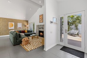 A modern living room with a sofa, coffee table, and fireplace.