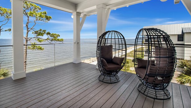 A covered deck with two black egg-shaped chairs and a view of the sea. - Plage d'Amour "Beach of Love" (Port Saint Joe)