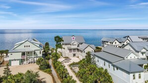 A coastal residential area with houses featuring a mix of architectural styles, including a prominent house with a star on the roof. - Plage d'Amour "Beach of Love" (Port Saint Joe)