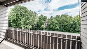 A wooden deck with a railing, overlooking a forested area. - Studio Cascades Sleeps 3 (Newry)