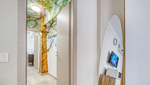 A hallway with a modern design, including a wooden cabinet with a microwave and a small TV. - Merlo C - town center & private parking (Ceriale)