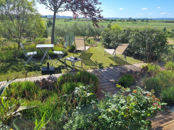 A garden with outdoor furniture, a small shed, and a view of the countryside.
