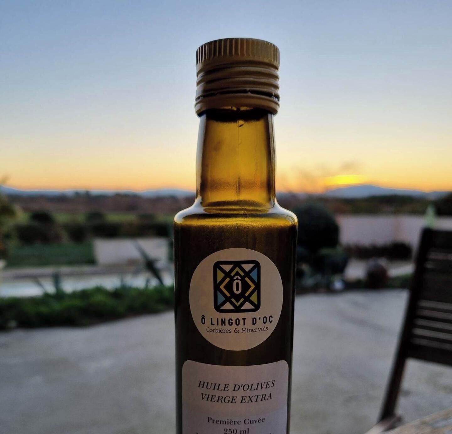 A bottle of Huiles d'Olives Vierge Extra wine with a label indicating it is a premium cuvée.