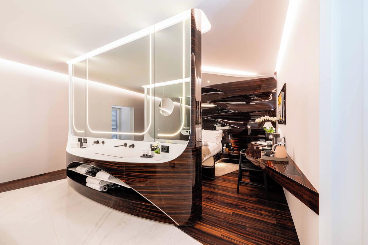 A modern bathroom with a large mirror, a vanity with a sink, and a shower area.