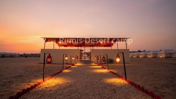 Un campo nel deserto con una struttura centrale e un vialetto sterrato che vi conduce.