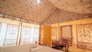 Una camera da tenda con un letto, una sedia e un tavolo.