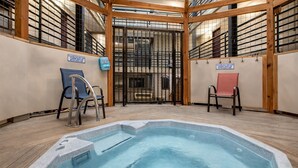 An indoor swimming pool with a wooden deck, two chairs, and a metal gate. - Rocky Mountain Escape At New Claim! 2 Bedroom Condo by RedAwning (Park City)