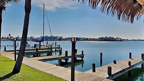 A wooden dock extending into calm water with a clear sky.