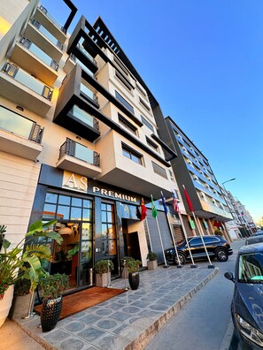 A multi-story hotel with a 'PREMIUM' sign, outdoor plants, and flags. - AS PREMIUM BY SOHO HOTELS (Casablanca)