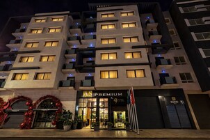 Un hotel de varios pisos con fachada moderna, balcones y entrada a nivel de calle con un letrero que dice 'AS PREMIUM'.