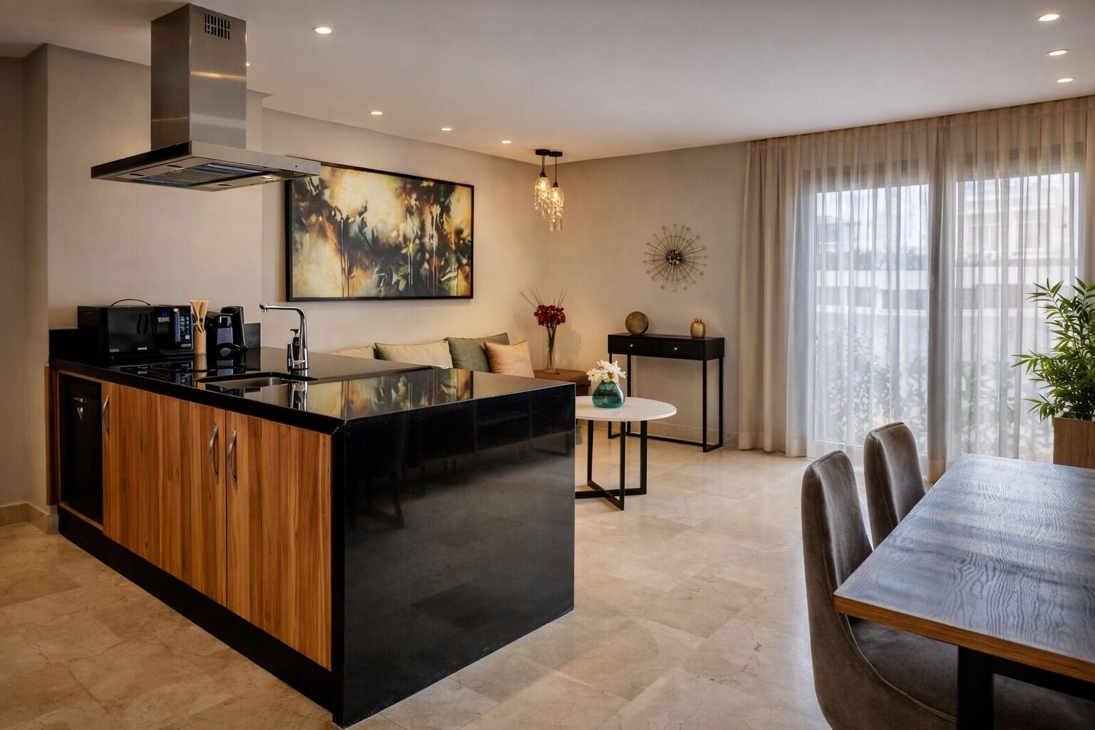 A modern kitchen with a central island, a dining area with a table and chairs, and a living space with a sofa and decorative items.